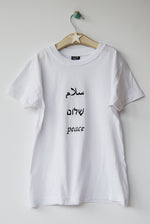 Salaam Shalom Peace in Arabic, Hebrew & English. White T-shirt with Black Writing. Simple and Minimal. Capsule Wardrobe.