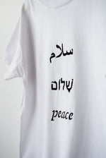 Salaam Shalom Peace in Arabic, Hebrew & English. White T-shirt with Black Writing. Simple and Minimal. Capsule Wardrobe.