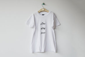 Salaam Shalom Peace in Arabic, Hebrew & English. White T-shirt with Black Writing. Simple and Minimal. Capsule Wardrobe.